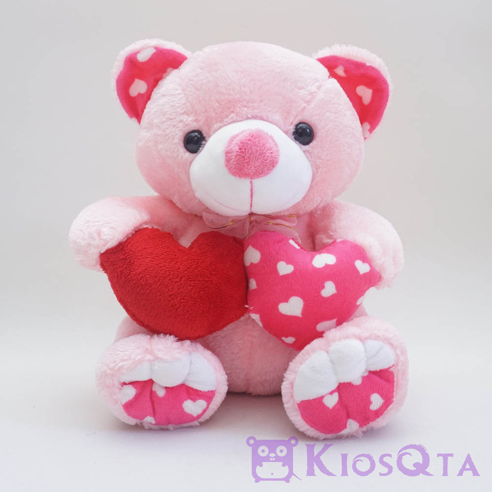 Boneka teddy bear pink duduk bawa dua hati
